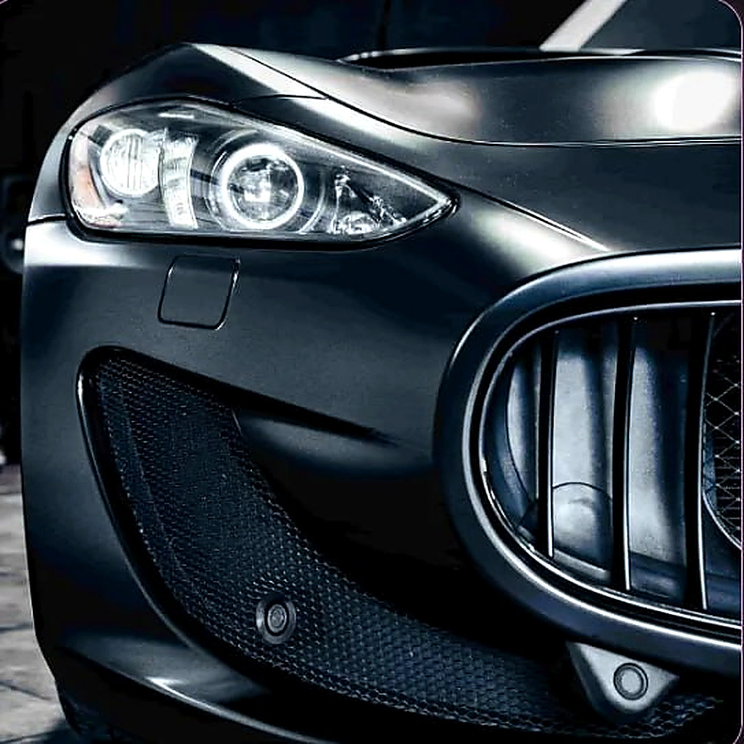 Satin grey Maserati front end with the headlight on